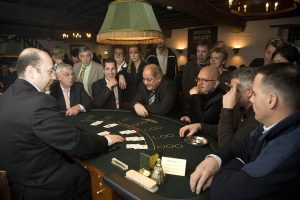 Players at a live casino card table